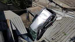 Sbanda sulla A20, sfonda guard rail e poi il tetto di un'officina: due feriti